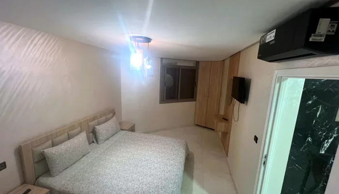Chambre avec lit double, téléviseur, climatiseur et placard - Appart'Hôtel Nador De Luxe