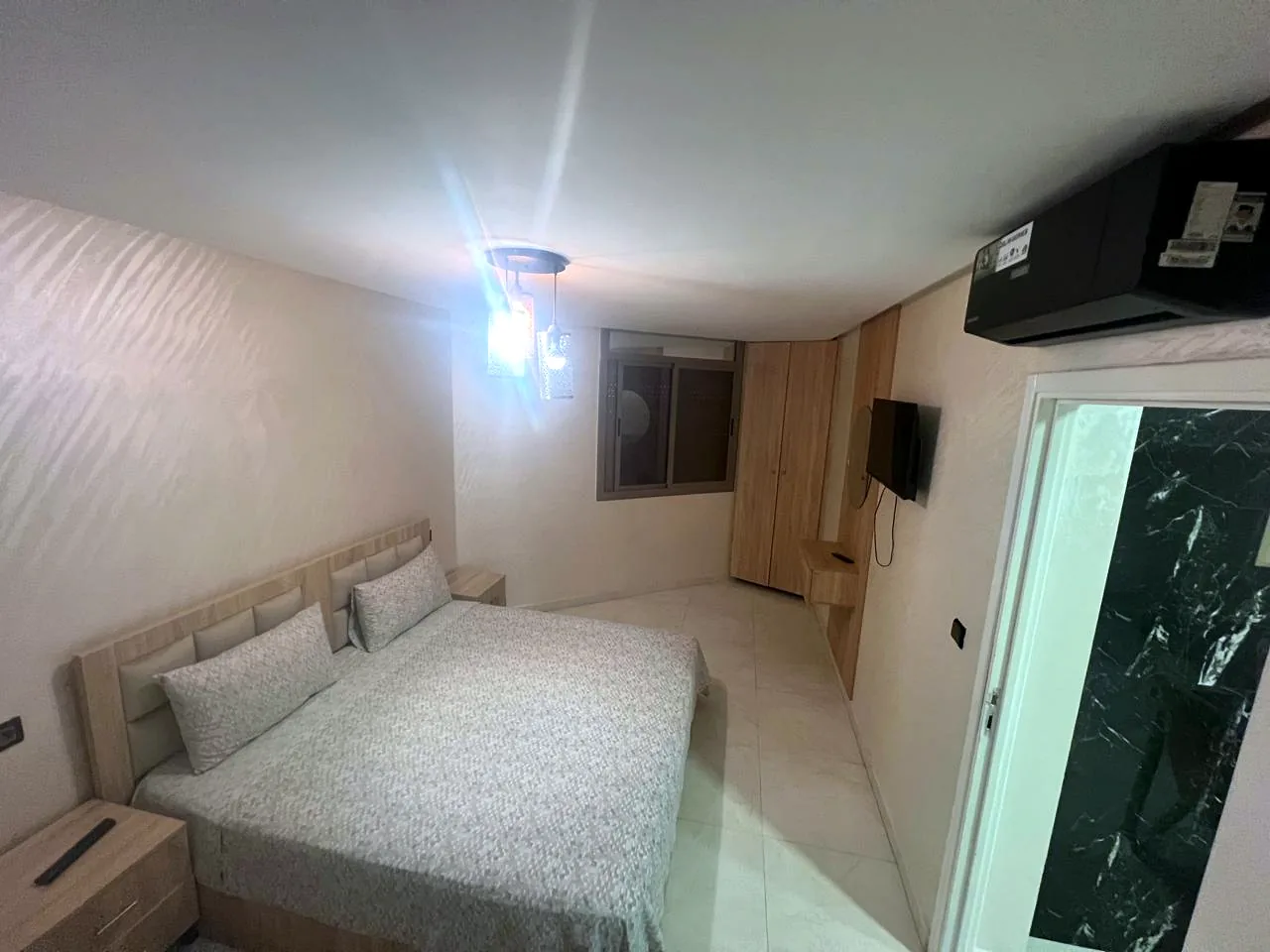 Chambre avec lit double, téléviseur, climatiseur et placard - Appart'Hôtel Nador De Luxe