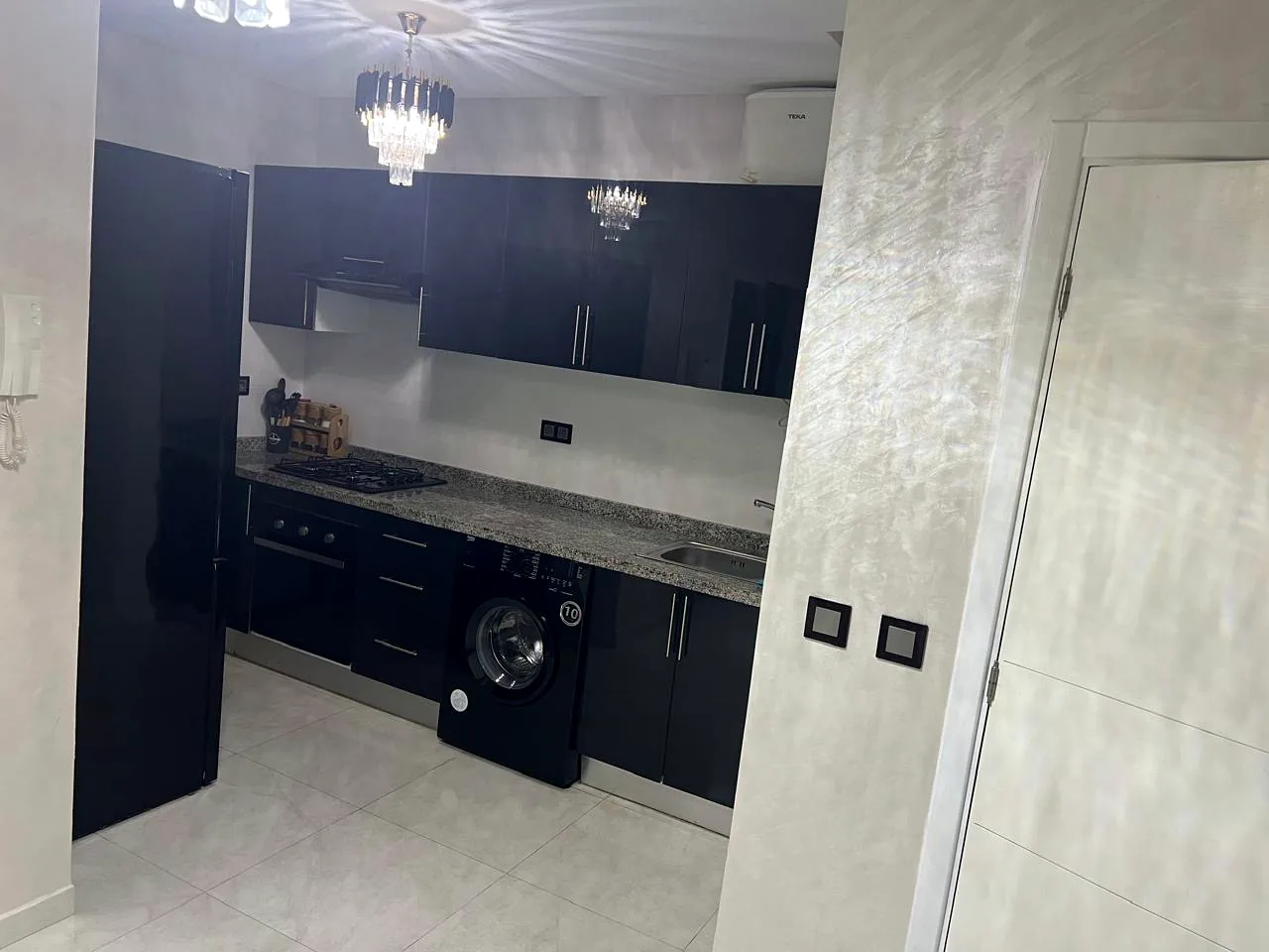 Cuisine équipée : four, plaque à gaz, lave-linge et plan de travail en granit - Appart'Hôtel Nador De Luxe