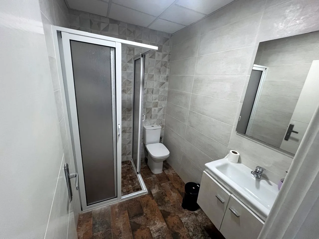 Salle de bain avec cabine de douche, WC et meuble vasque - Appart'Hôtel Nador De Luxe
