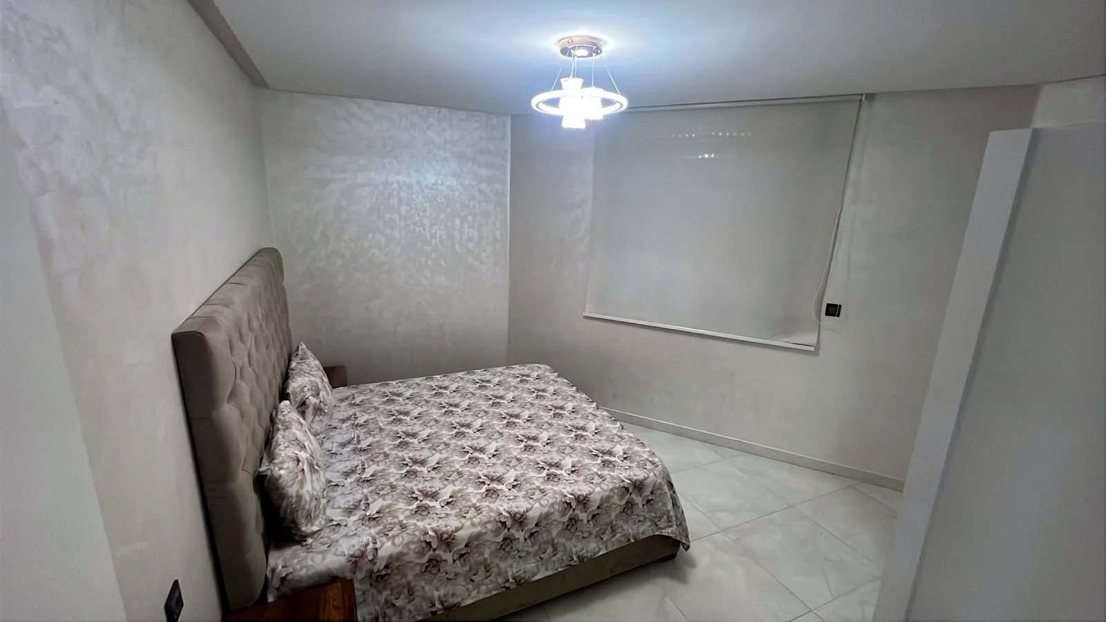 Chambre avec lit double et tête de lit capitonnée - Appart'Hôtel Nador De Luxe