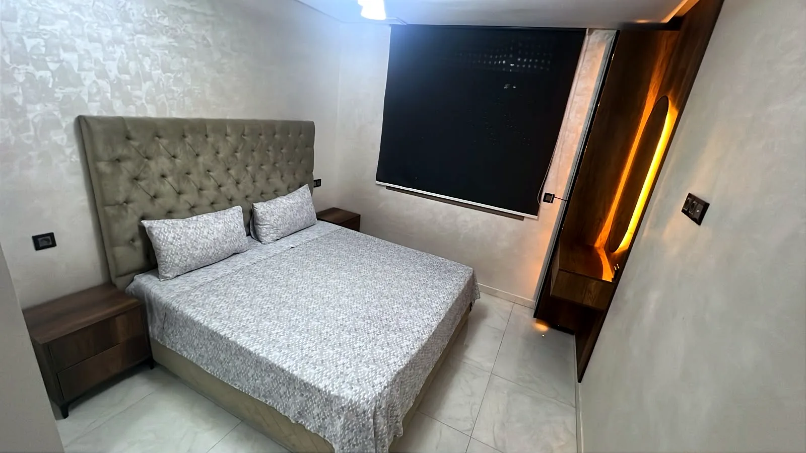 Chambre avec lit double, tête de lit capitonnée et panneau bois rétroéclairé - Appart'Hôtel Nador De Luxe