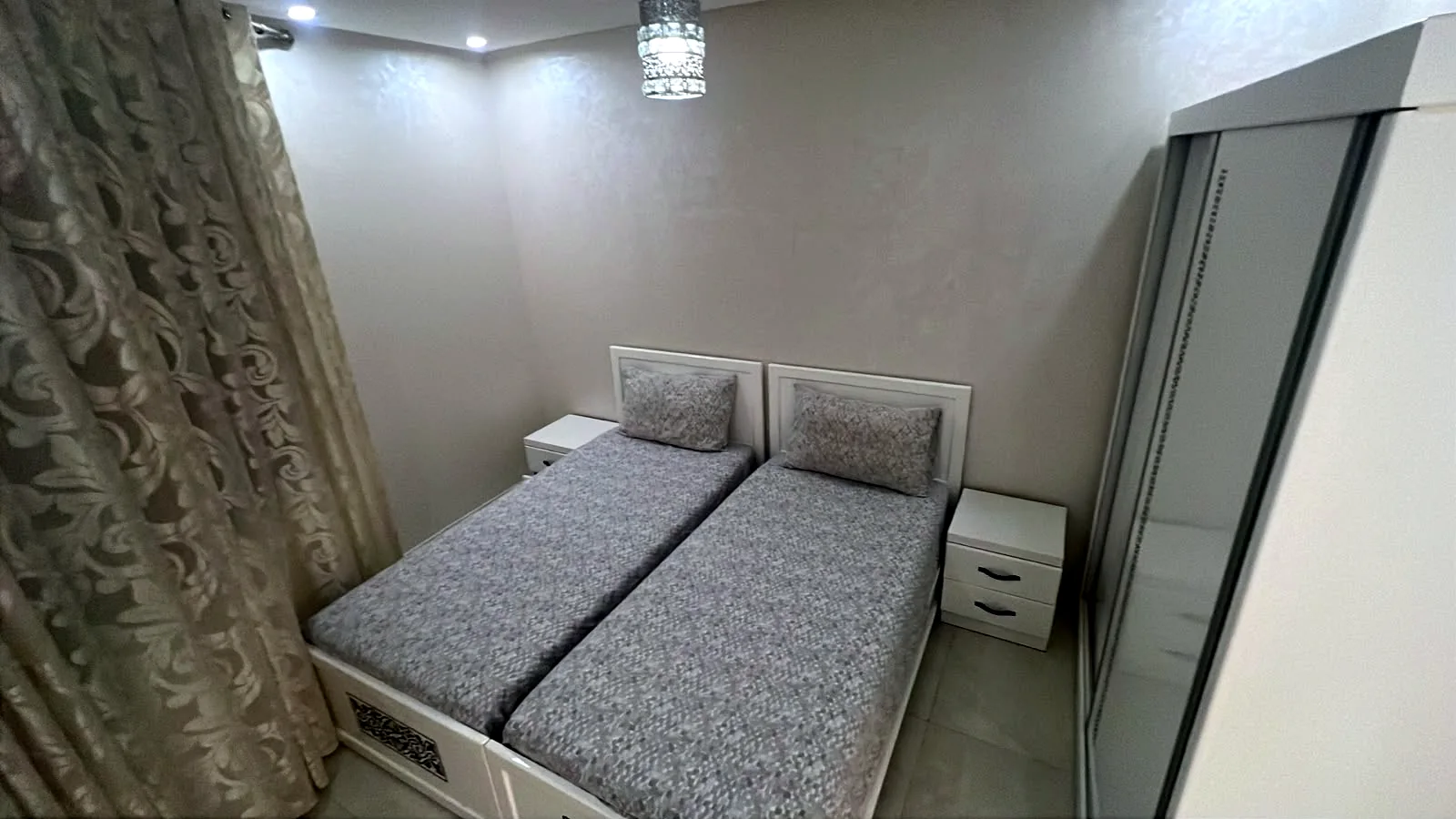 Deuxième chambre avec deux lits simples et armoire - Appart'Hôtel Nador De Luxe